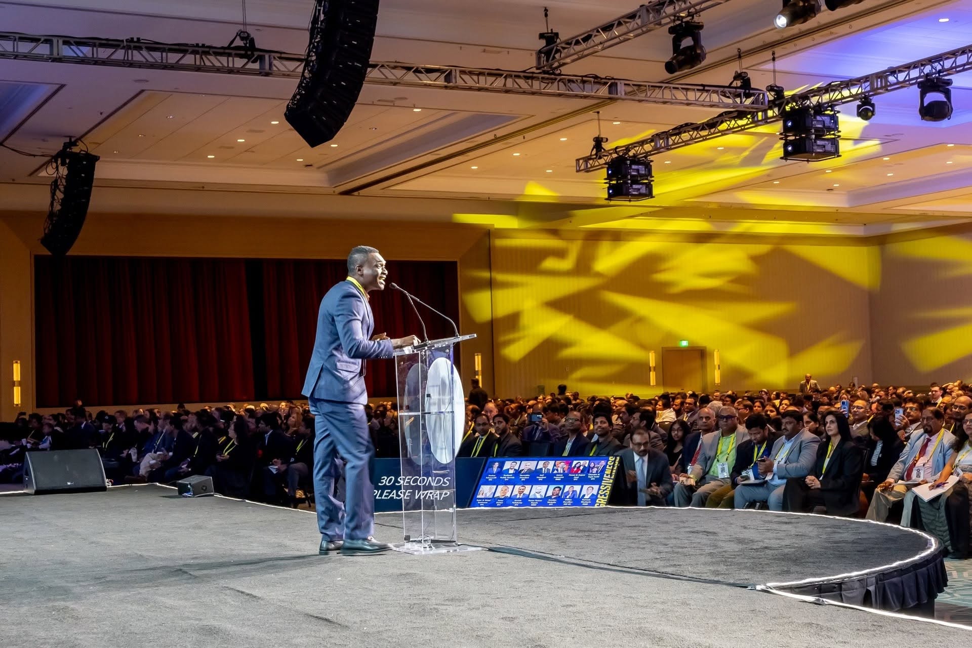 Wilken Dorcilien speaking before a large conference audience